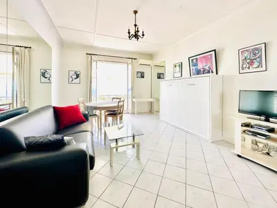 a living room with a couch and a table at Miramar - Studio Croisette - Vue Mer Panoramique in Cannes