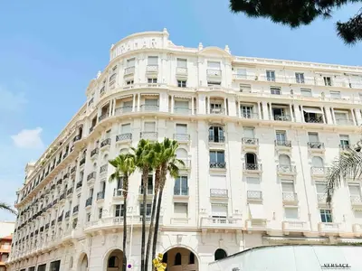 a large white building with palm trees in front of it at Le Belmondo - Studio Croisette - Palais Miramar in Cannes