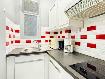 a kitchen with red and white tiles on the wall at Le Belmondo - Studio Croisette - Palais Miramar in Cannes