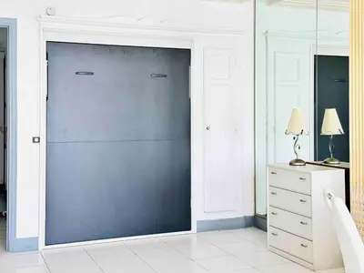 a sliding glass door in a room with a dresser at Le Belmondo - Studio Croisette - Palais Miramar in Cannes
