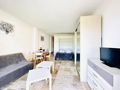 a living room with a couch and a tv at Grand Hotel - Studio Croisette in Cannes