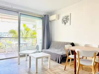 a living room with a bed and a table and chairs at Grand Hotel - Studio Croisette in Cannes