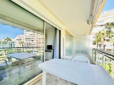 a room with a table and a balcony with a view at Grand Hotel - Studio Croisette in Cannes