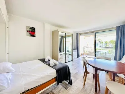 a bedroom with a bed and a table and a dining room at Grand Hotel - Studio Croisette in Cannes