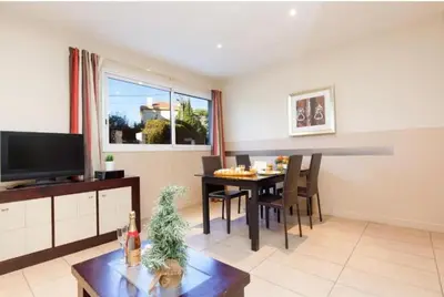 a living room with a table and a dining room at Centre ville à 5 mn à pied du Palais et plages in Cannes