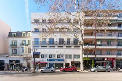 a street with cars parked in front of a building at Centre ville à 5 mn à pied du Palais et plages in Cannes