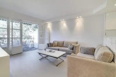 a living room with two couches and a table at Appartement calme et confortable -terrasse- Cannes in Cannes