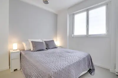 a white bedroom with a bed and a window at Appartement calme et confortable -terrasse- Cannes in Cannes