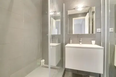 a white bathroom with a sink and a mirror at Appartement calme et confortable -terrasse- Cannes in Cannes