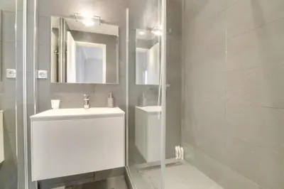 a white bathroom with a sink and a mirror at Appartement calme et confortable -terrasse- Cannes in Cannes
