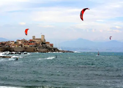 a group of people flying kites in the ocean at CannesVacationRental by AmericanVacationLIving 1BR in Cannes