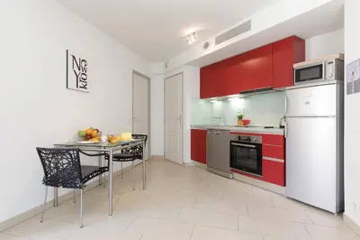 a kitchen with red cabinets and a table with chairs at Greg YourHostHelper in Cannes