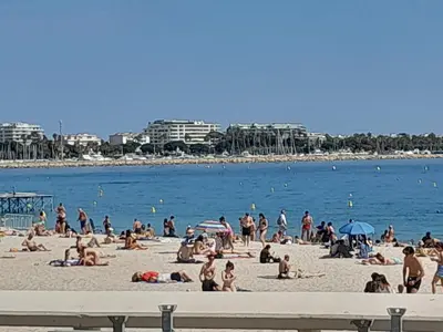a group of people sitting on a beach at World Apartment Cannes in Cannes