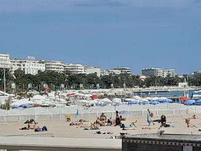 a group of people laying on a beach with umbrellas at World Apartment Cannes in Cannes