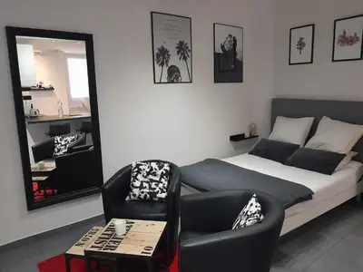 a bedroom with a bed and a chair and a mirror at World Apartment Cannes in Cannes