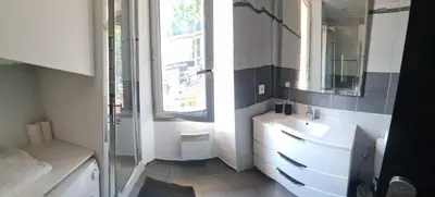 a bathroom with a sink and a mirror and a window at World Apartment Cannes in Cannes