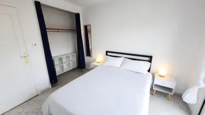 a white bedroom with a white bed and two lamps at Sunny Mercury - Room in Apartment in Cannes