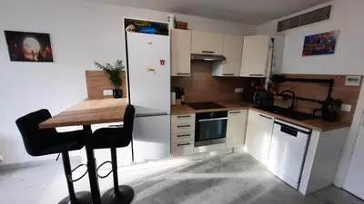 a small kitchen with a table and a refrigerator at Sunny Mercury - Room in Apartment in Cannes