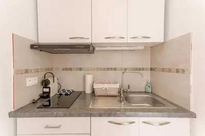 a kitchen with white cabinets and a sink at Lisa's Rooftop - Toit-terrasse à 2mn du Palais et des plages de la Croisette in Cannes