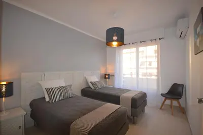 a bedroom with two beds and a chair and a window at 