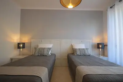 two beds in a room with two lamps on the wall at 