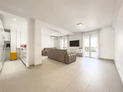 a large living room with a couch and a tv at Le Maubourg by Winsome Destination in Cannes