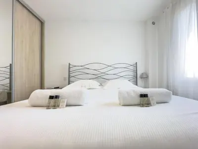 a white bed with two white pillows on it at Le Maubourg by Winsome Destination in Cannes