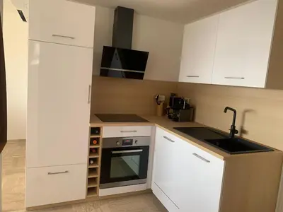 a small kitchen with white cabinets and a sink at Cannes vue mer in Cannes