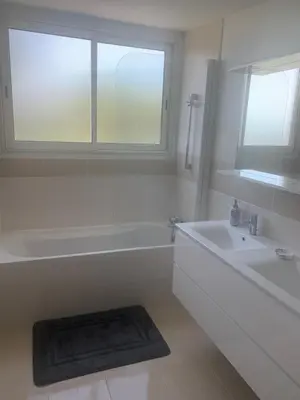 a white bathroom with a tub and a sink at Cannes vue mer in Cannes
