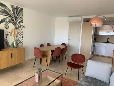a living room with a dining room table and chairs at Cannes vue mer in Cannes
