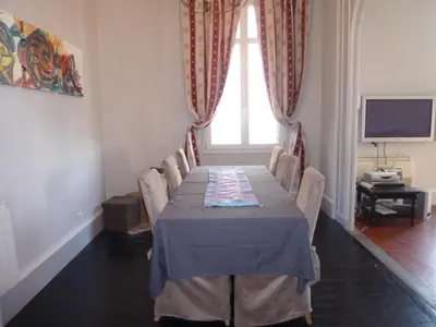 a dining room with a table with chairs and a television at ANNA CLAIRE festival plages GAZ5213 in Cannes