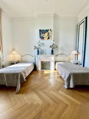 two beds in a white room with a fireplace at ANNA CLAIRE festival plages GAZ5213 in Cannes