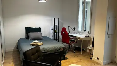 a small bedroom with a bed and a chair at Appartment Cannes City Centre in Cannes