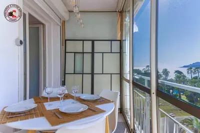 a dining room with a table and chairs and a balcony at Lido Sea View, Congrès & Plage, clim, terrasse vue mer in Cannes