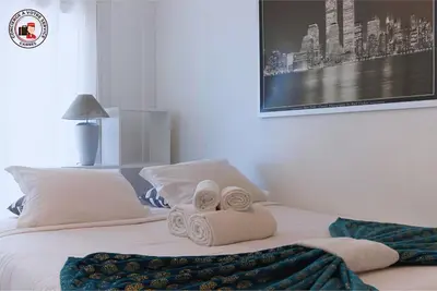 a bedroom with a bed with two rolled towels at Lido Sea View, Congrès & Plage, clim, terrasse vue mer in Cannes