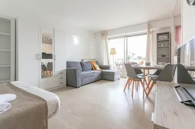 a living room with a couch and a table with chairs at Studio with Huge Terrace close to the beach-Clim Mobile- BENAKEY in Cannes