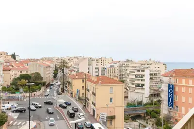 a city street with cars and buildings and the ocean at Studio with Huge Terrace close to the beach-Clim Mobile- BENAKEY in Cannes