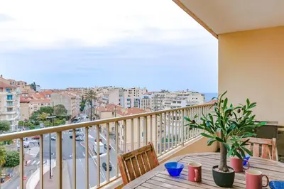 a balcony with a table and a view of a city at Studio with Huge Terrace close to the beach-Clim Mobile- BENAKEY in Cannes
