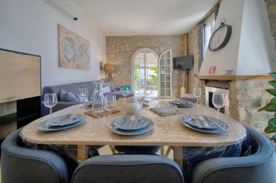 a dining room with a table with plates and wine glasses at IMMOGROOM - T3 - Garden - Quiet - Air conditioning in Cannes