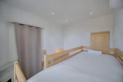 a bedroom with a bed with a wooden frame at IMMOGROOM - T3 - Garden - Quiet - Air conditioning in Cannes