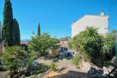 a house with palm trees and a building at IMMOGROOM - T3 - Garden - Quiet - Air conditioning in Cannes