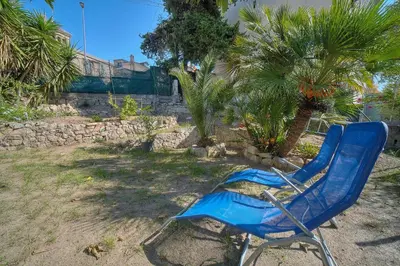 a blue chair sitting in a yard with palm trees at IMMOGROOM - T3 - Garden - Quiet - Air conditioning in Cannes