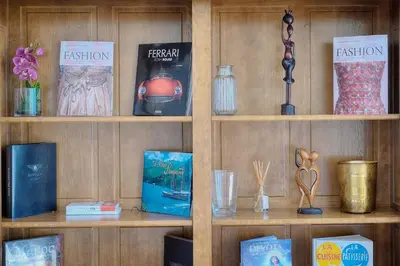 a book shelf with books and other items on it at IMMOGROOM - T5 de standing - 130m - Terrace - Parking - AC in Cannes
