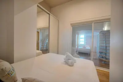 a white room with a bed and a mirror at IMMOGROOM - T5 de standing - 130m - Terrace - Parking - AC in Cannes