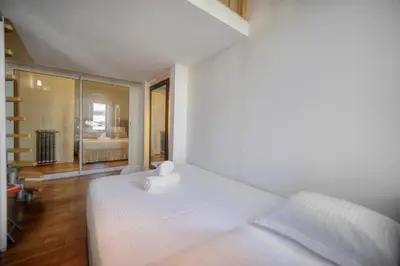 a white bed in a room with a window at IMMOGROOM - T5 de standing - 130m - Terrace - Parking - AC in Cannes