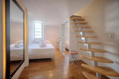 a bedroom with a spiral staircase next to a bed at IMMOGROOM - T5 de standing - 130m - Terrace - Parking - AC in Cannes
