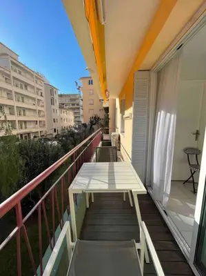 a balcony with a wooden table on a building at Renovated Cannes Centre Banane balcon in Cannes