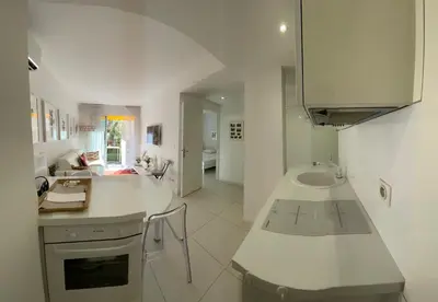 a white kitchen with a sink and a counter at Renovated Cannes Centre Banane balcon in Cannes