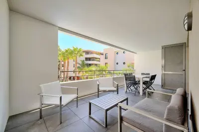 a living room with a balcony with a table and chairs at Appartement , piscine, terrasse, proche croisette in Cannes