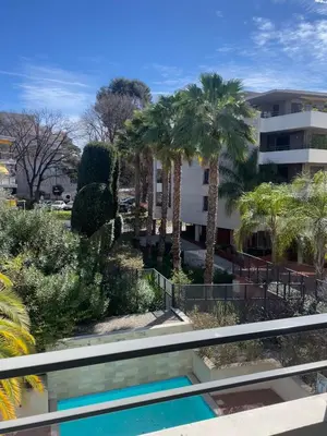 a view of a resort with palm trees and a swimming pool at Appartement , piscine, terrasse, proche croisette in Cannes